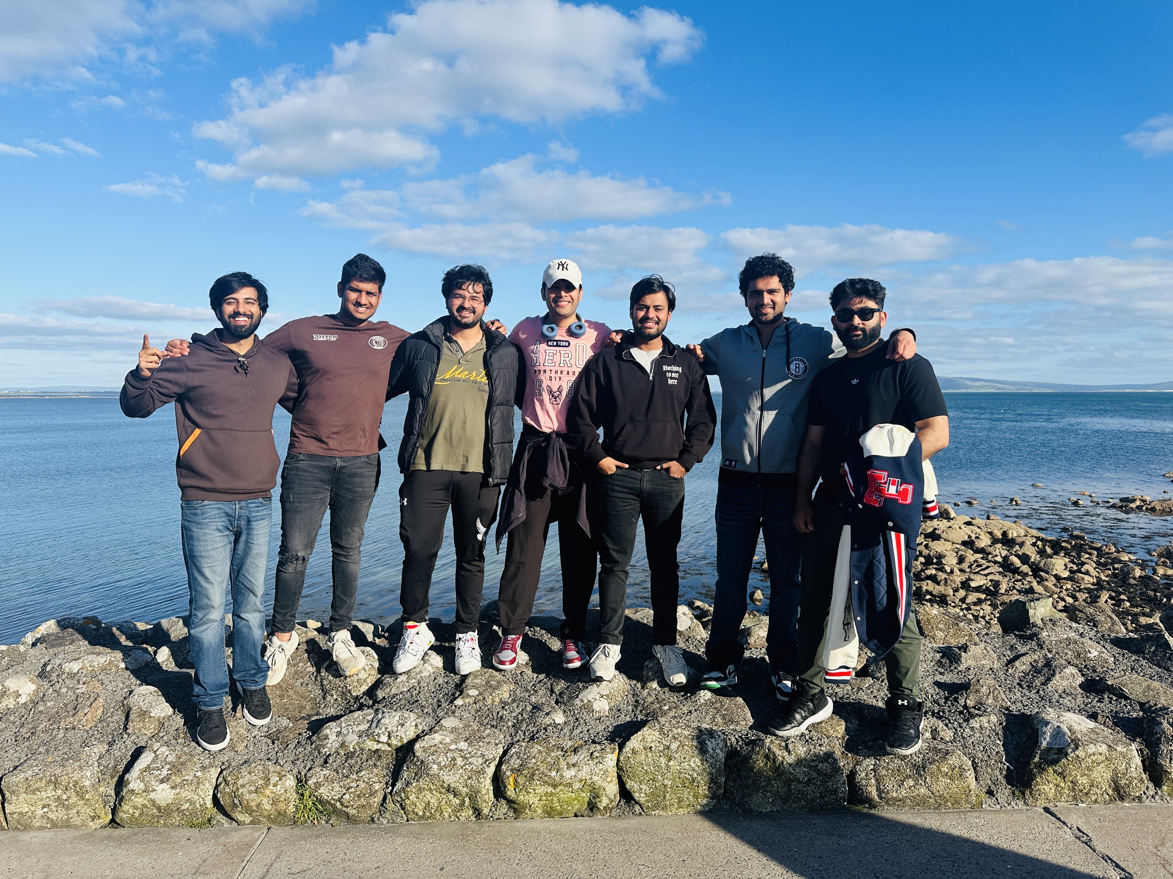 A group of seven friends posing for a photo on the rocks in Salthill
