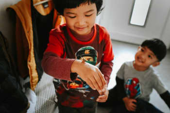 two young boys sitting on the floor playing with a toy