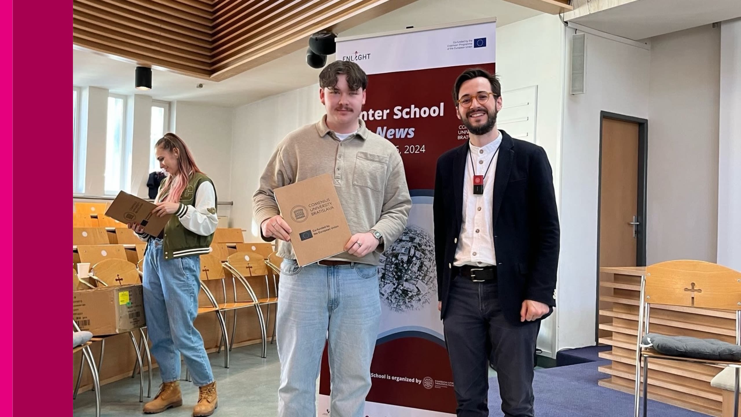 Two people standing in a lecture hall.
