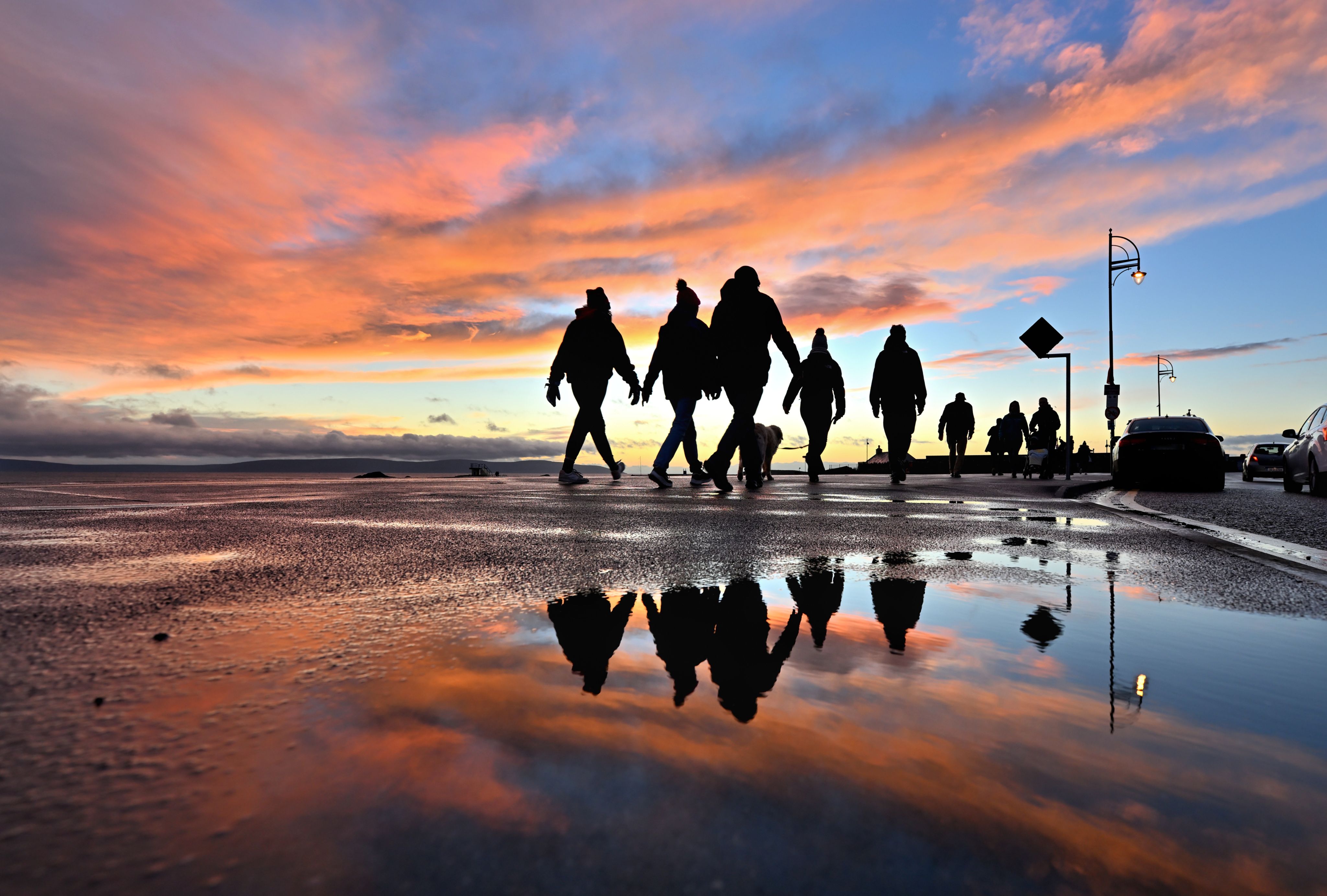 photo of people walking on a shore