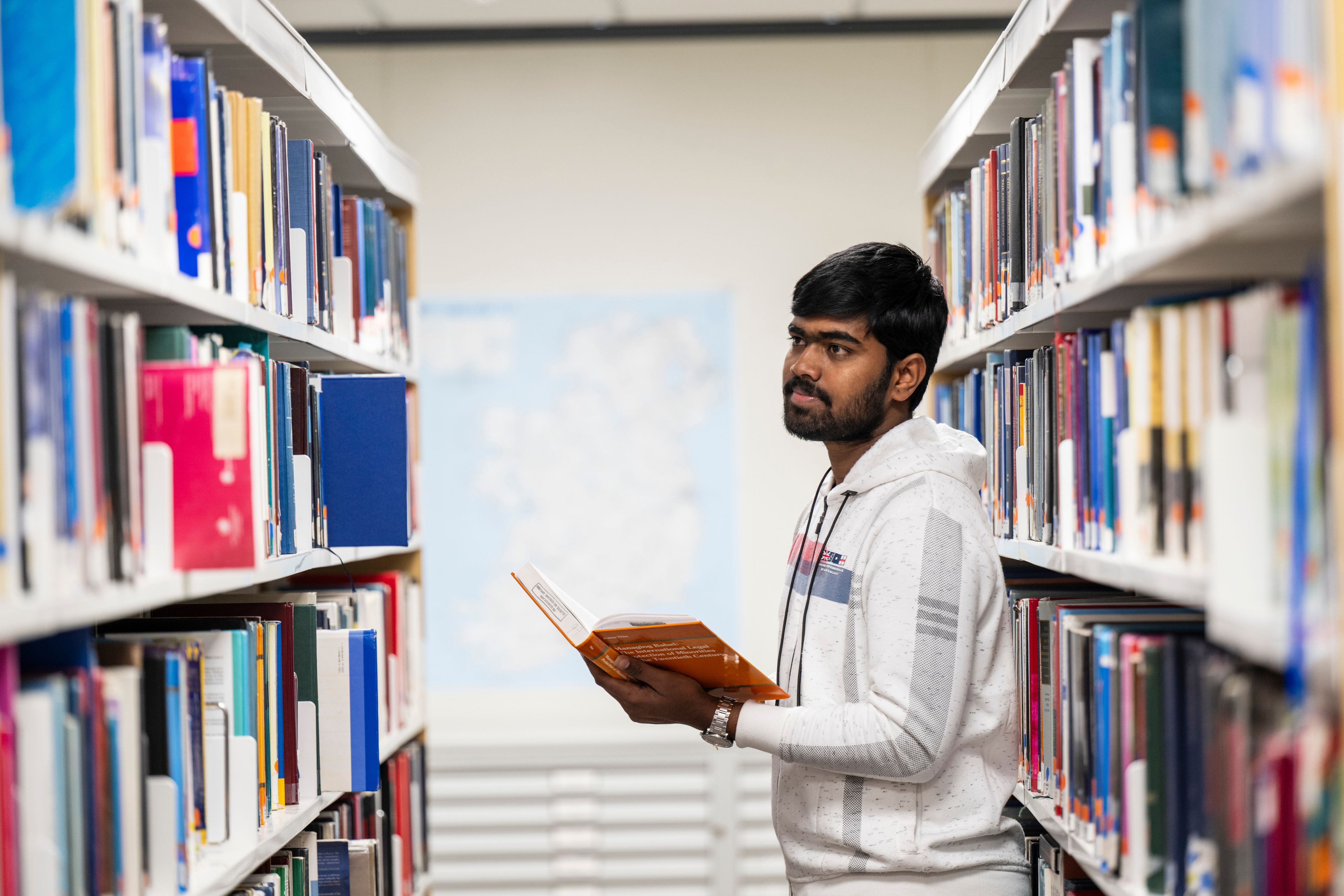 A student in the library reading a book